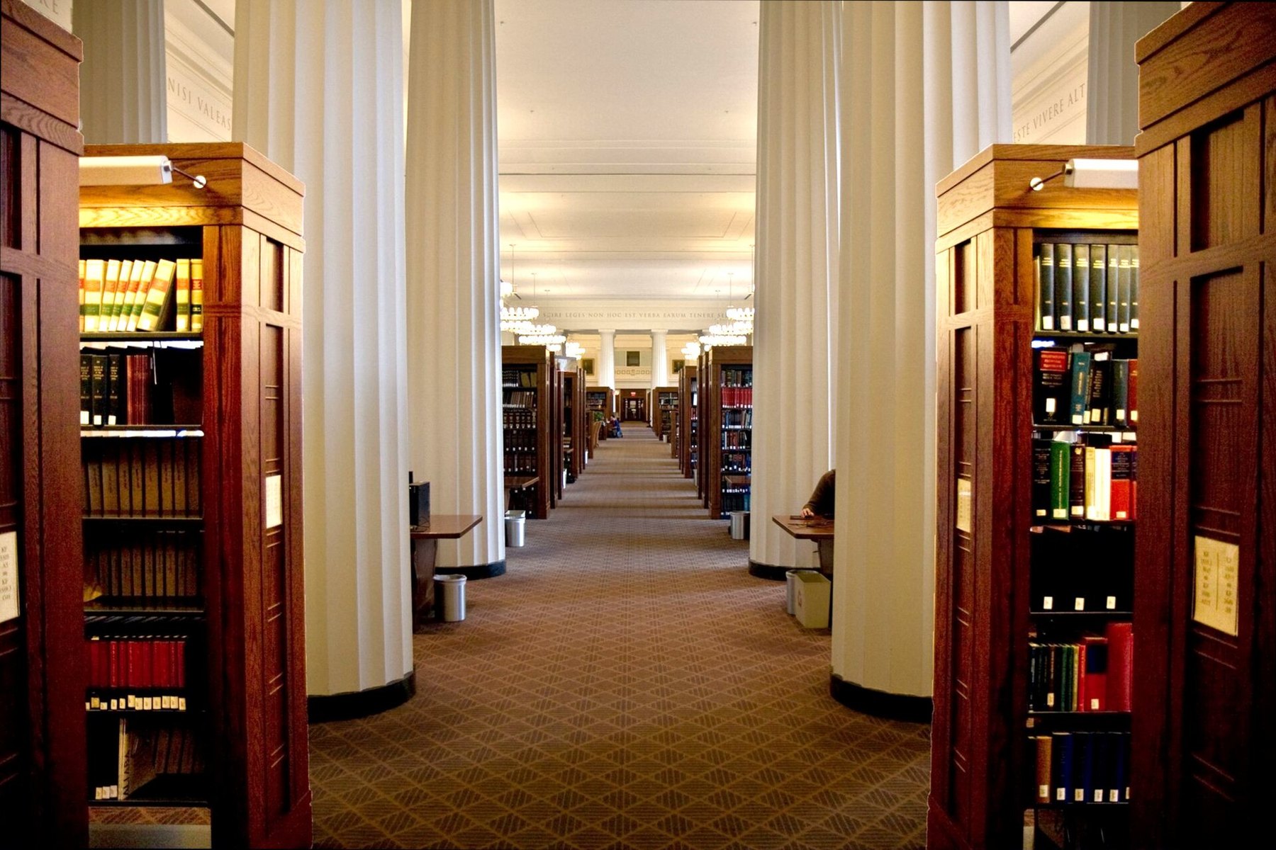 Interior of a modern law library with reading tables and legal collections.